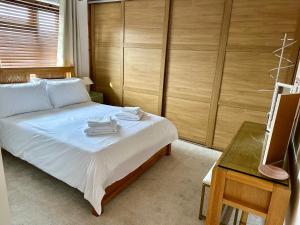 a bedroom with a bed and a desk and a television at Central Taunton Townhouse in Taunton