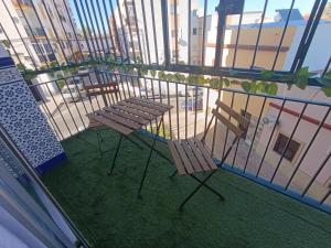 a balcony with two chairs and a table at Sevilla Gateway a 10 min Sevilla y cerca aeropuerto, 3 habitaciones, 2 camas en cada habitación y sofá cama in Alcalá de Guadaira