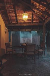 a dining room with a table and chairs and a ceiling at Catumaran Jaffna in Jaffna +1 photo