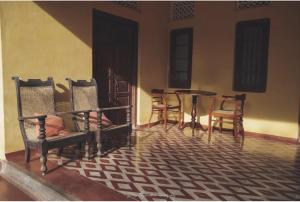 a room with chairs and a table and a table and chairs at Catumaran Jaffna in Jaffna