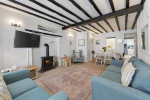 a living room with blue couches and a tv at 3 Bed in Croyde oc-2ingle in Croyde