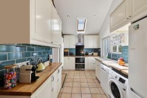a kitchen with white cabinets and blue tiles at 3 Bed in Croyde oc-2ingle in Croyde