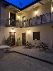 a patio with tables and a balcony in a building at Maison Federica in Colà di Lazise