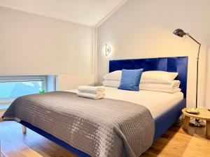 a bedroom with a large bed with a blue headboard at MINT Luxury Apartments at the Main Square in Krakow