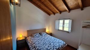 a bedroom with a bed and two lamps on tables at Monte Sardão in Cavaleiro