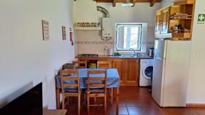 a kitchen with a table and a white refrigerator at Monte Sardão in Cavaleiro