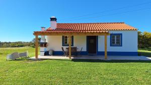 a small blue and white house with a red roof at Monte Sardão in Cavaleiro