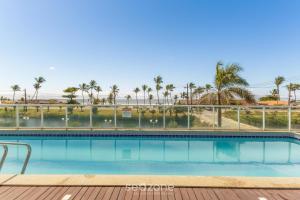 a swimming pool with a view of the beach and palm trees at Condominium w/ pool and steps fr/ the beach - SRCs in Ilhéus
