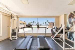 a gym with two tread machines and a large window at Condominium w/ pool and steps fr/ the beach - SRCs in Ilhéus