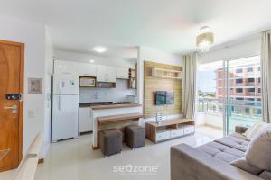 a living room with a couch and a kitchen at Condominium w/ pool and steps fr/ the beach - SRCs in Ilhéus