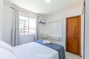 a white bedroom with a bed and a window at Condominium w/ pool and steps fr/ the beach - SRCs in Ilhéus +25 photos