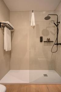 a shower with a glass door in a bathroom at Hotel Faisanera Golf in Palazuelos de Eresma
