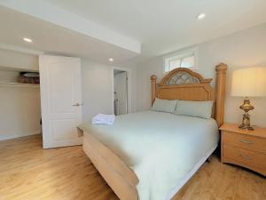 a bedroom with a large bed and a wooden headboard at Cozy Rooms in Bright Walkout Suite - Newly Renovated in 2026 in Richmond Hill