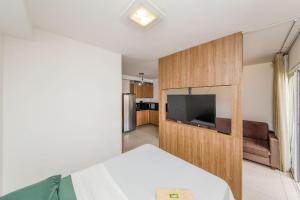 a bedroom with a bed and a tv in a room at Studio Be Happy! piscina academia coz completa in Juiz de Fora