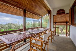a dining room with a long wooden table and chairs at Elaion House in Agia Paraskevi
