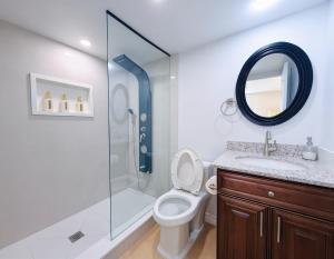 a bathroom with a toilet and a shower with a mirror at Cozy Rooms in Bright Walkout Suite - Newly Renovated in 2026 in Richmond Hill