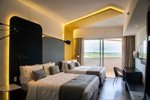 a hotel room with two beds and a balcony at Taua Hotel e Convention Alexania in Alexânia +45 photos