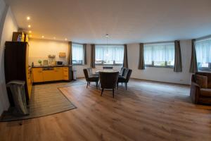 a living room with a table and chairs and a kitchen at Ferienwohnung an der Zwota in Klingenthal