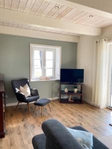 a living room with a couch and a tv at Deichhof Knudsen in Oldsum