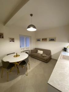 a living room with a table and a couch at Maison Federica in Colà di Lazise