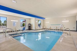 a pool in a hotel room with chairs at Cobblestone Hotel & Suites Waukesha West Milwaukee in Waukesha