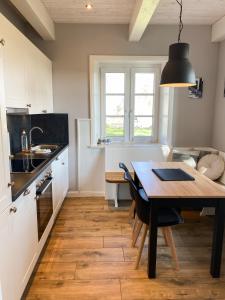 a kitchen with a wooden table and a dining room at Deichhof Knudsen in Oldsum
