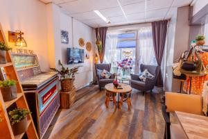 a living room with a large flat screen tv and a table at Hotel de Burg in Domburg