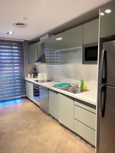 a kitchen with white counters and a refrigerator at Pearl Properties three bedroom apartment in Trofwi