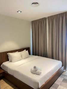 a bedroom with a bed with two towels on it at Pearl Properties three bedroom apartment in Trofwi