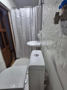 a small bathroom with a toilet and a sink at BridgeStayHostel in Samarkand