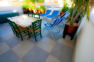 a patio with a table and chairs and potted plants at Old Style by the sea, roof terrace with pool and kitchen, Ladispoli in Ladispoli