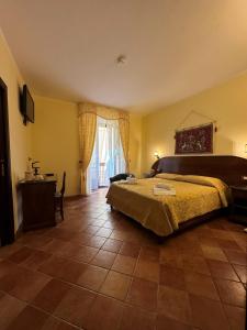 a bedroom with a bed and a table and a window at Palazzo Mascambruno in Cariati