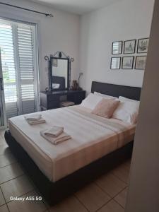 a bedroom with a large bed and a mirror at SUNNY COAST in Paralimni