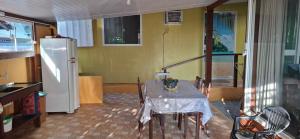 a dining room with a table and a refrigerator at Kitinet Container próximo Praia e Beto Carrero in Penha