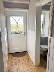a bathroom with a door with a window at Deichhof Knudsen in Oldsum +27 photos