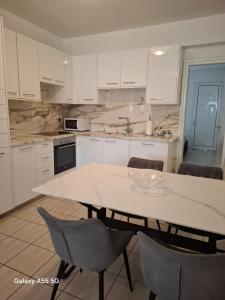 a kitchen with white cabinets and a table and chairs at SUNNY COAST in Paralimni