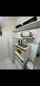 a small kitchen with a microwave and a toilet at Nid douillet in Montpellier