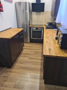 a kitchen with wooden counters and stainless steel appliances at Oasis City Central in Tarnowskie Góry