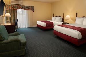 ein Hotelzimmer mit zwei Betten und einem Stuhl in der Unterkunft Carlyle Hotel in Campbell + 35 Fotos