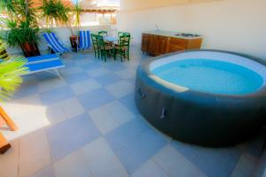 a large tub in a room with a table and chairs at Old Style by the sea, roof terrace with pool and kitchen, Ladispoli in Ladispoli