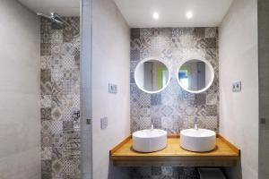 2 lavabos en un baño con 2 espejos en Meeting Point Hostels, en Barcelona