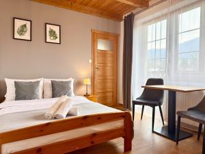 a bedroom with a bed with a desk and chairs at Willa Maya in Karpacz