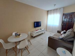 a living room with a couch and a table at Casa Marinho - Pé na praia in Saquarema
