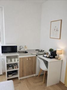a kitchen with a counter and a sink and a table at Studio moderne cosy Centre-ville in Auxerre