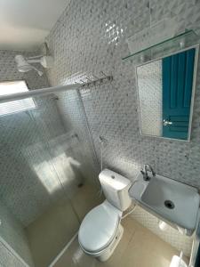 a bathroom with a toilet and a sink and a mirror at Casa Aconchego do Mar in Japaratinga +56 photos