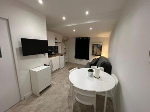 a small living room with a white table and a tv at Léopard vert - Clim - Tout inclus in Aubagne