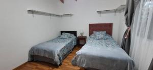 a bedroom with two beds and a window at Casa Ika Moana in Hanga Roa