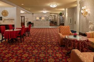 eine Hotellobby mit Tischen und Stühlen und einem Warteraum in der Unterkunft Carlyle Hotel in Campbell