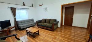 a living room with two couches and a television at Casa Ika Moana in Hanga Roa