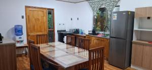 a kitchen with a table and a refrigerator at Casa Ika Moana in Hanga Roa